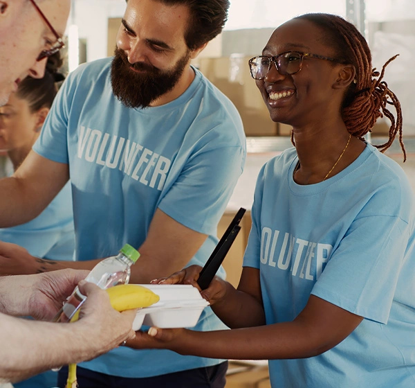 Volunteers serving a man some food